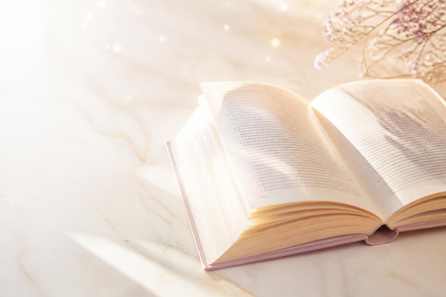 Livro antigo aberto com luz dourada subindo de suas páginas